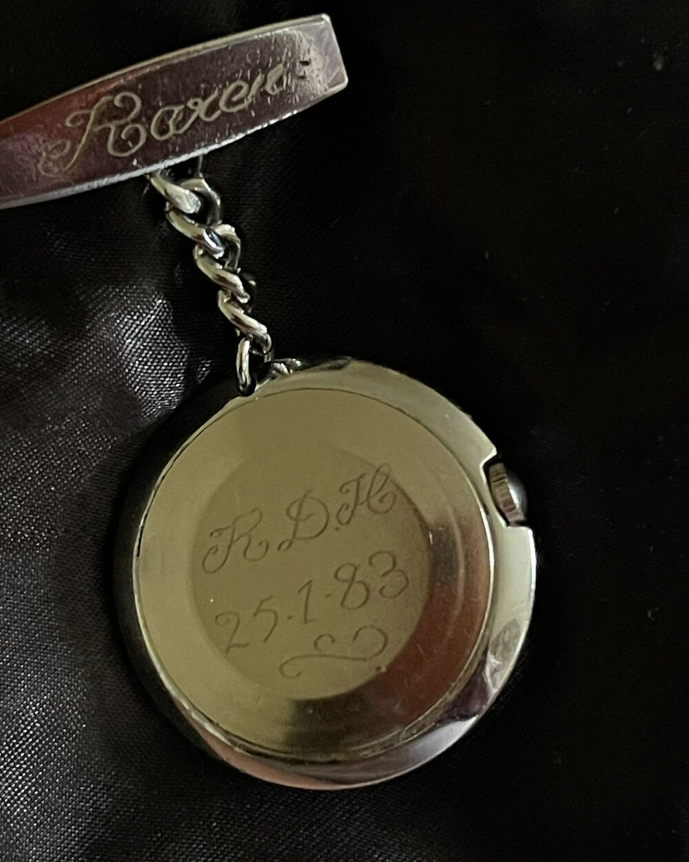 A photo of the back of an old pocket watch with the initials RDH
